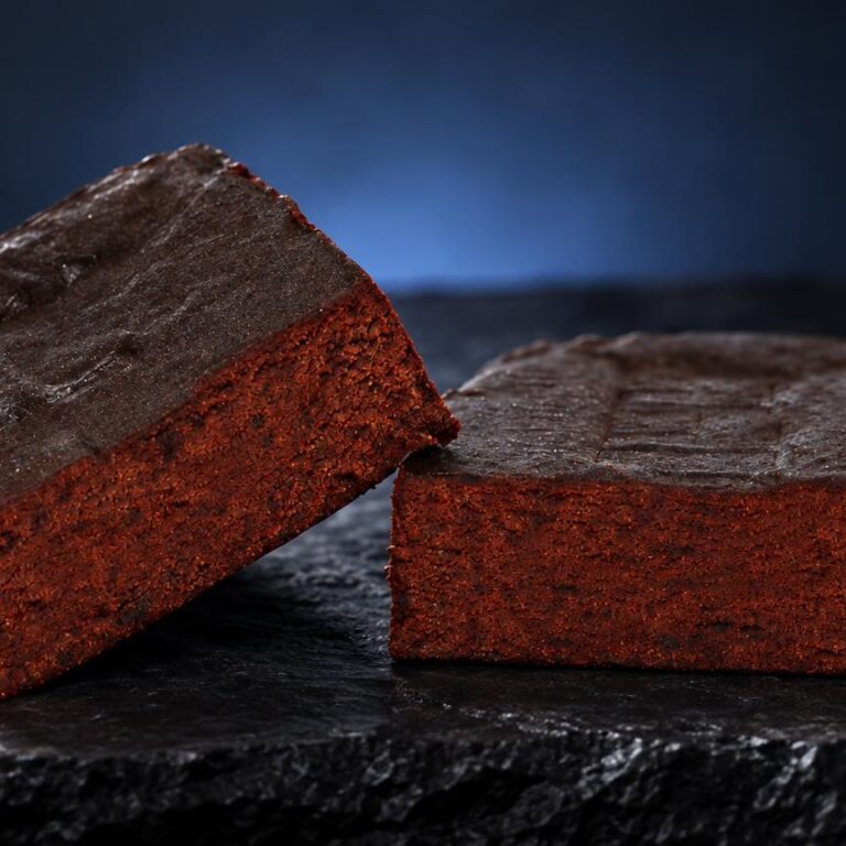 Beldia : deux briques de haschisch rouge brique avec croûte grise, posées sur pierre noire