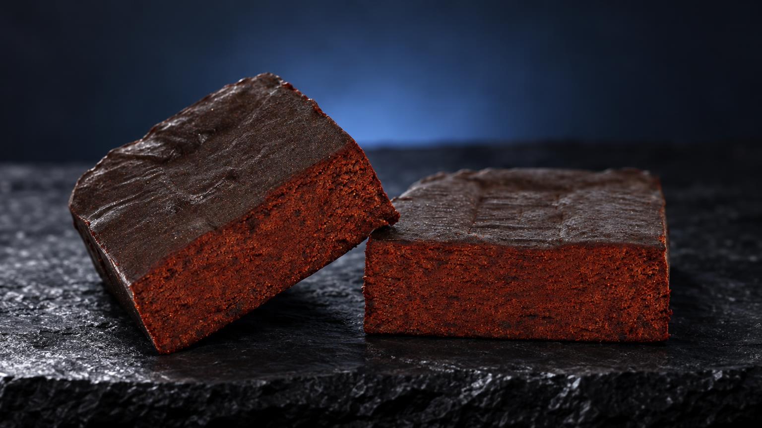 Beldia : deux briques de haschisch rouge brique avec croûte grise, posées sur pierre noire