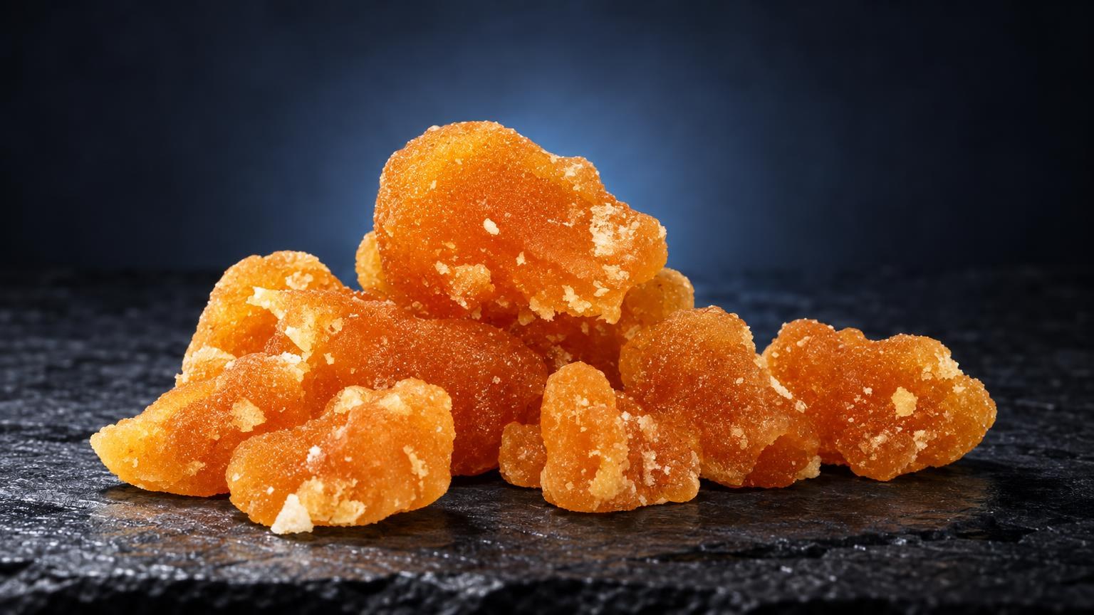 Bubble hash: cristal Bubble con textura granulosa y color ámbar dorado, aglomerados en montículo sobre superficie oscura
