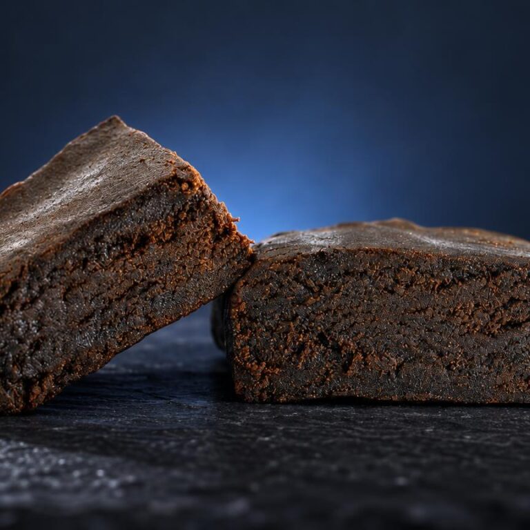 Deux blocs de Hash 3x filtré de couleur marron clair, texture granuleuse compacte, posés sur surface sombre