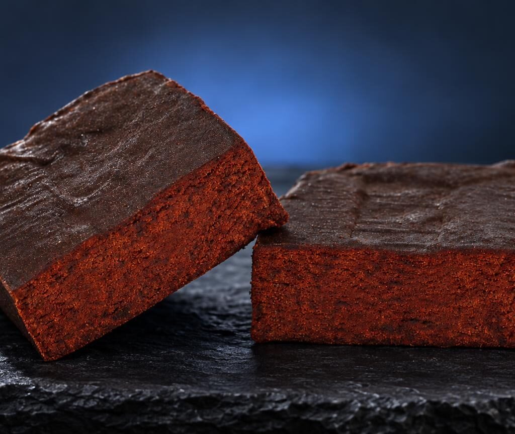 Deux blocs de Libanais Rouge aux faces rouges vif et sommets bruns, posés sur une surface noire brillante