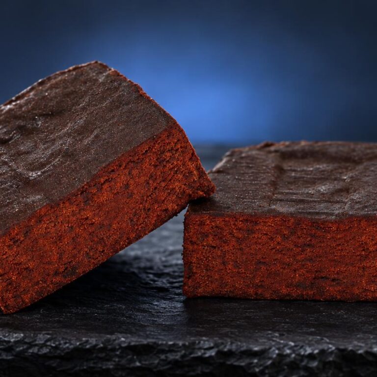 Deux blocs de Libanais Rouge aux faces rouges vif et sommets bruns, posés sur une surface noire brillante