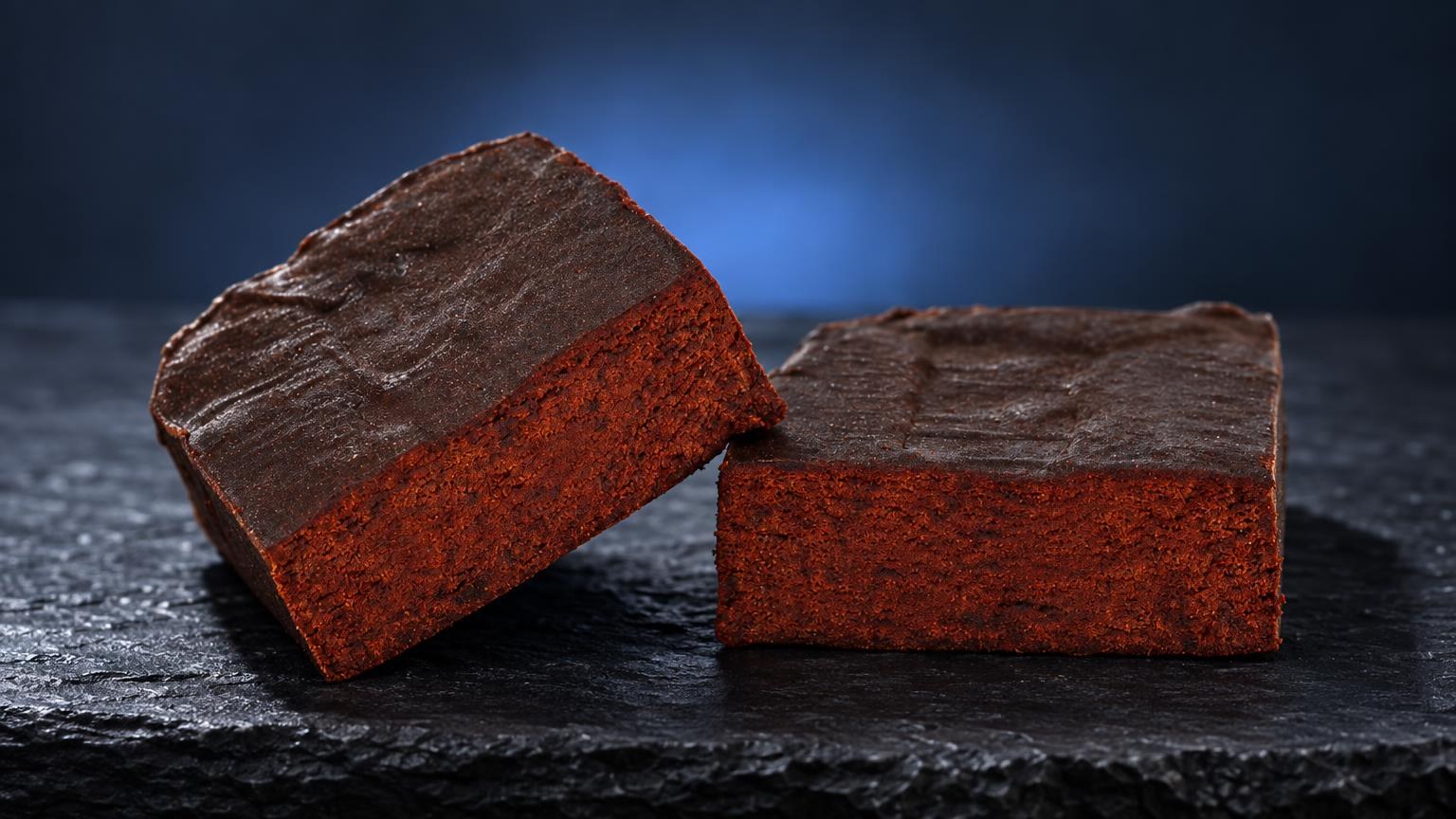 Deux blocs de Libanais Rouge aux faces rouges vif et sommets bruns, posés sur une surface noire brillante